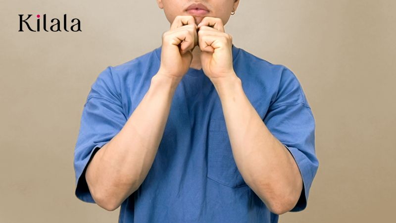 đặt ngón tay cái dưới cằm